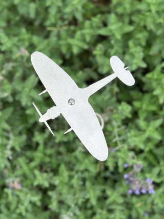 Stainless steel Spitfire garden ornament viewed from above on spiral stake, catching the light.