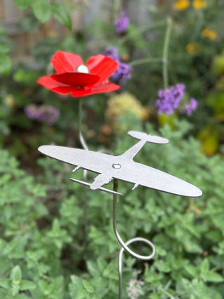 Stainless steel Spitfire ornament on spiral stake, photographed with poppy flowers to mark Remembrance.